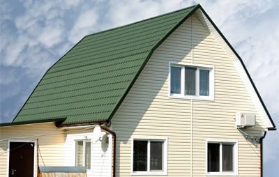 Дом из сайдинга с зеленой крышей